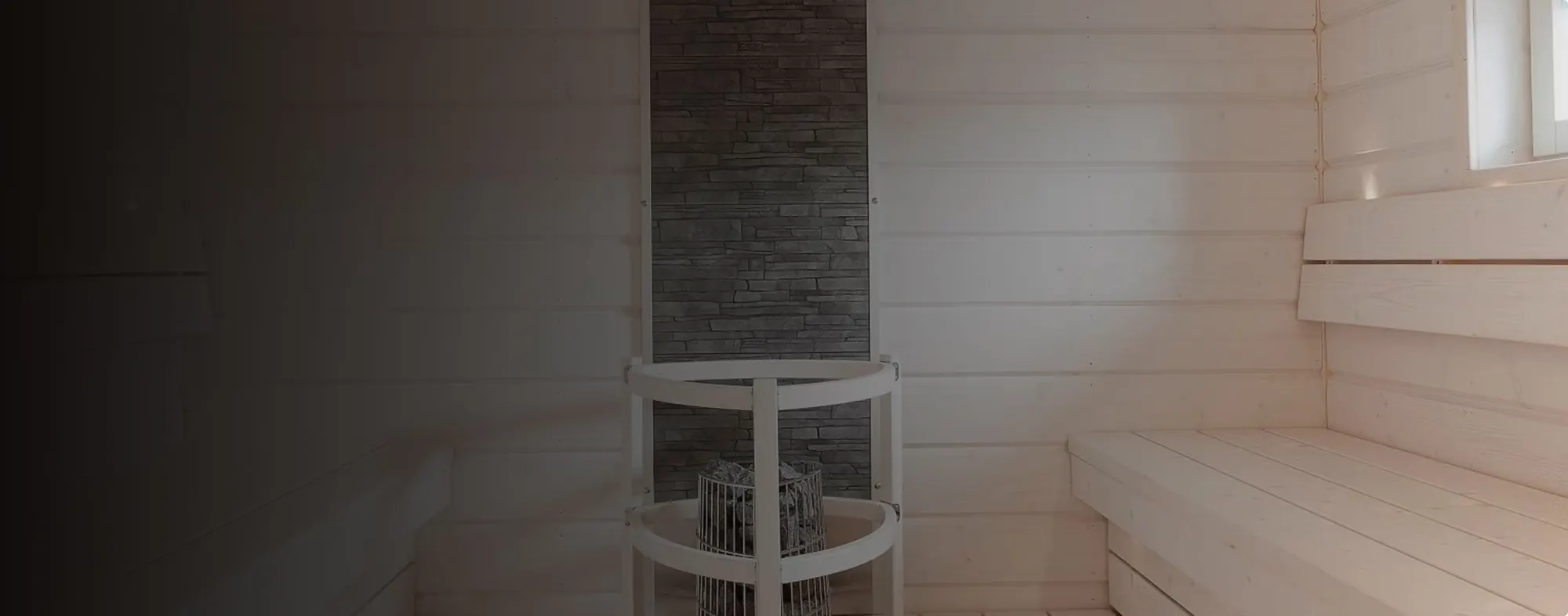 White timber sauna with a round heater and a stone feature wall